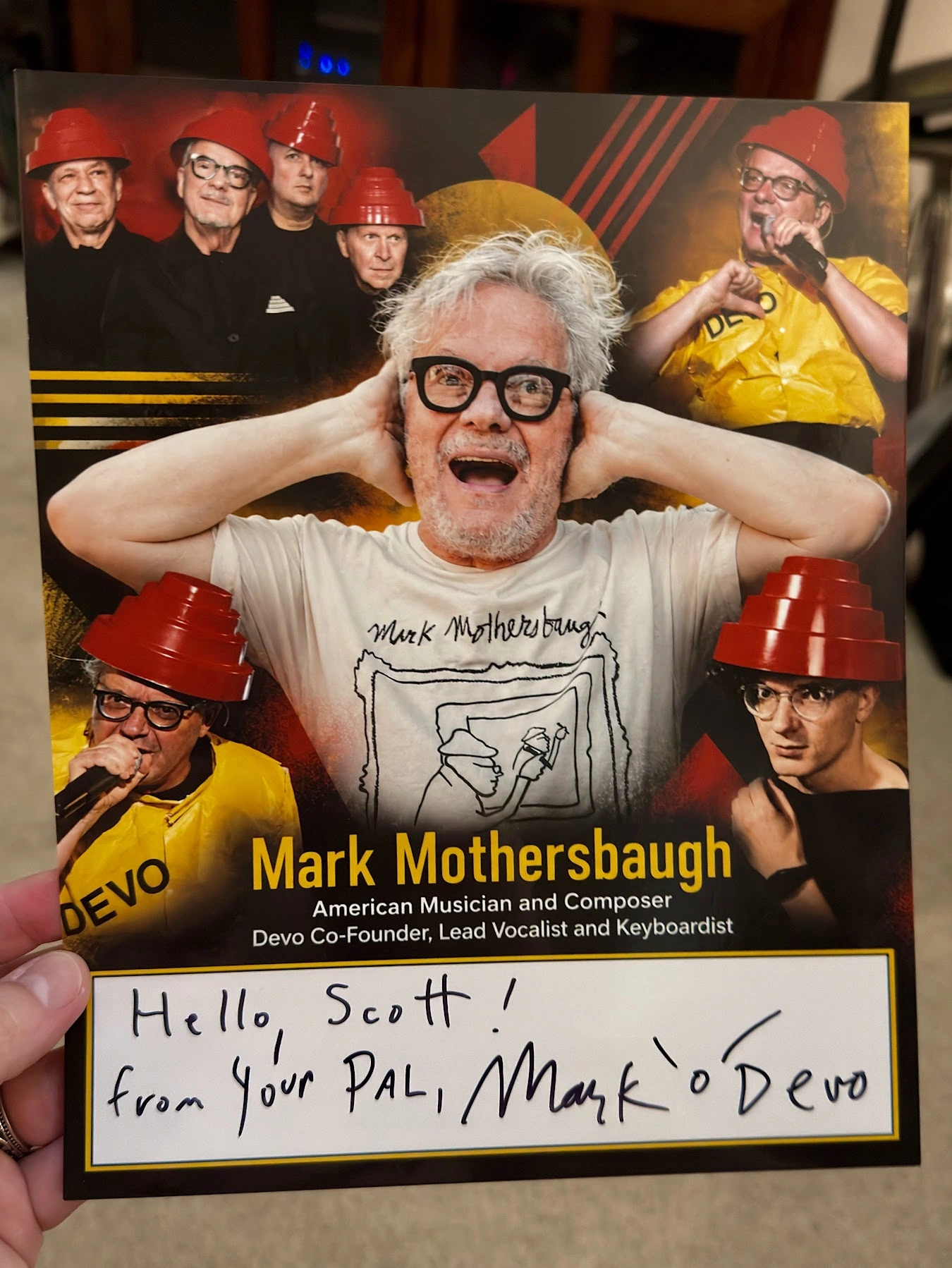 Scott Brooks holding his custom Mark Mothersbaugh collage featuring DEVO photos, returned with a handwritten Hello Scott message and autograph.